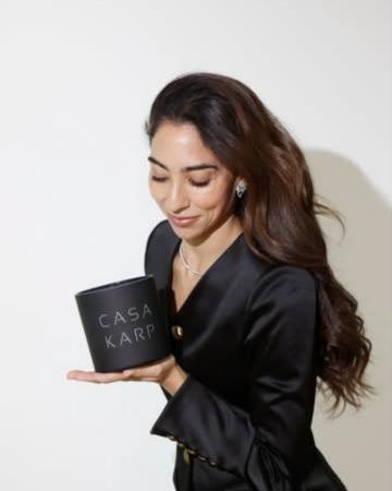 A woman in black holding a black Casa Karp cylinder candle