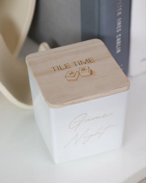 A wooden lid engraved Tile time on a white Game Night candle