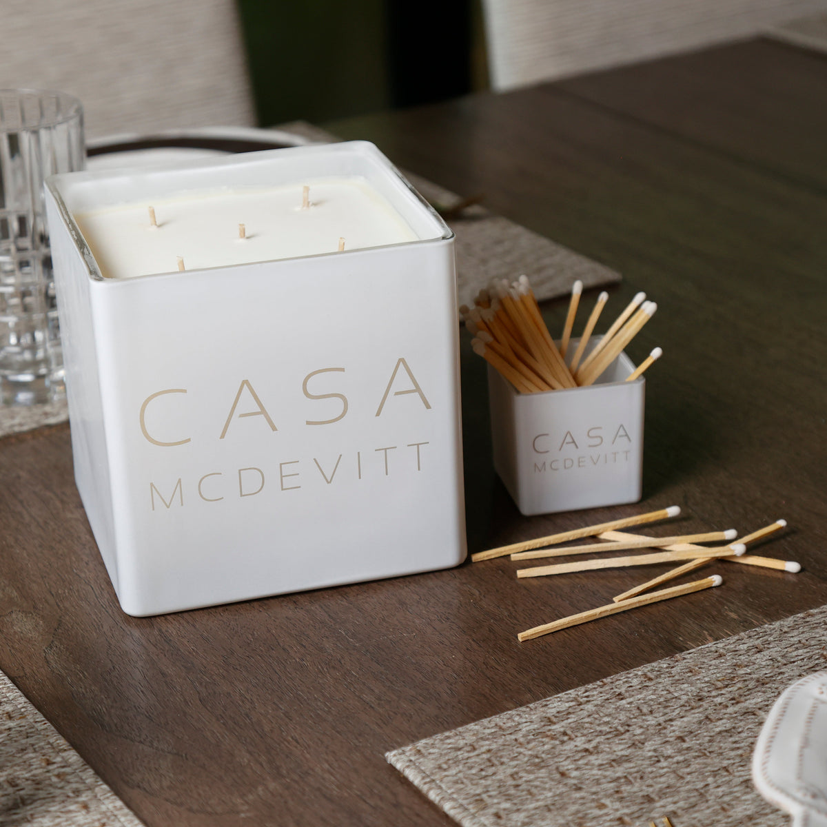 White Casa candle engraved McDevitt with matches on a wooden table