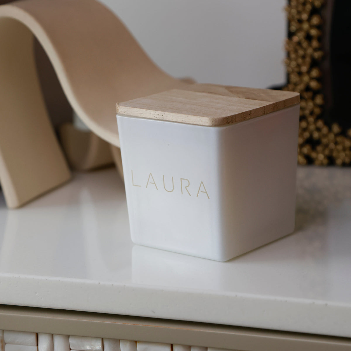 White candle engraved Laura in the TAJA font