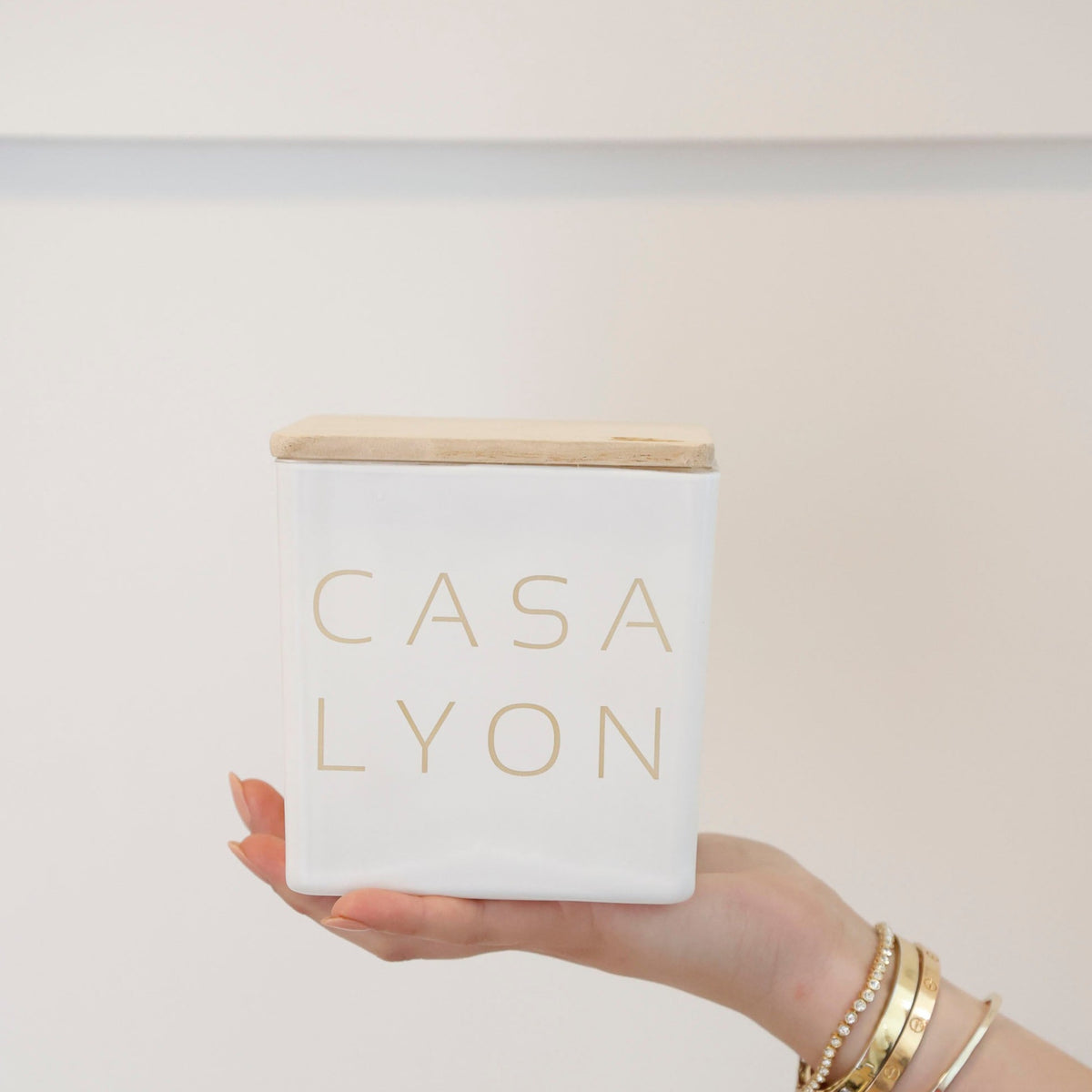 White Casa candle engraved Lyon, held in one hand