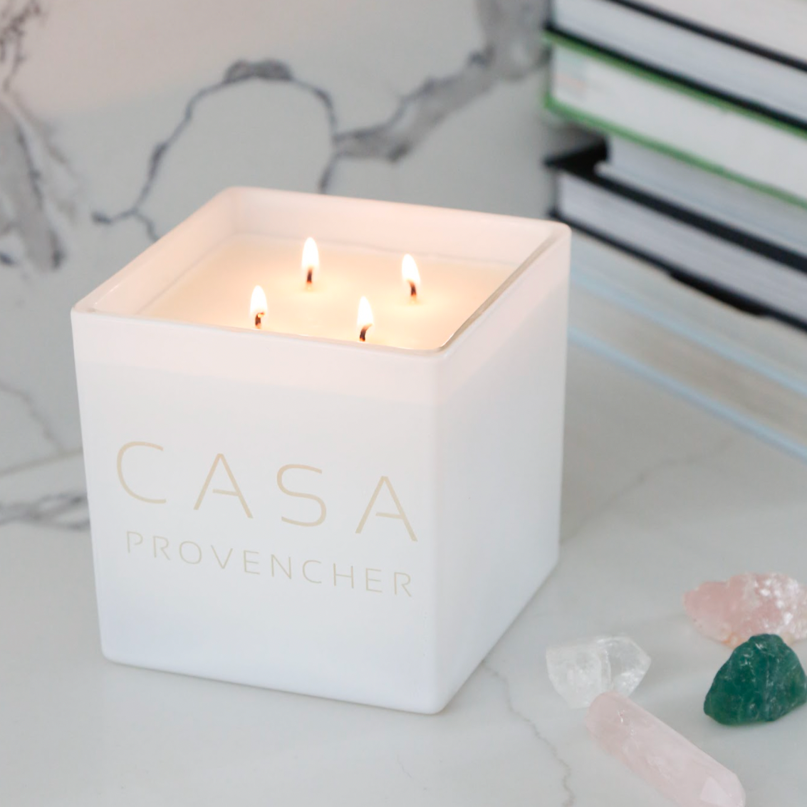 Lit white Casa candle on a marble counter