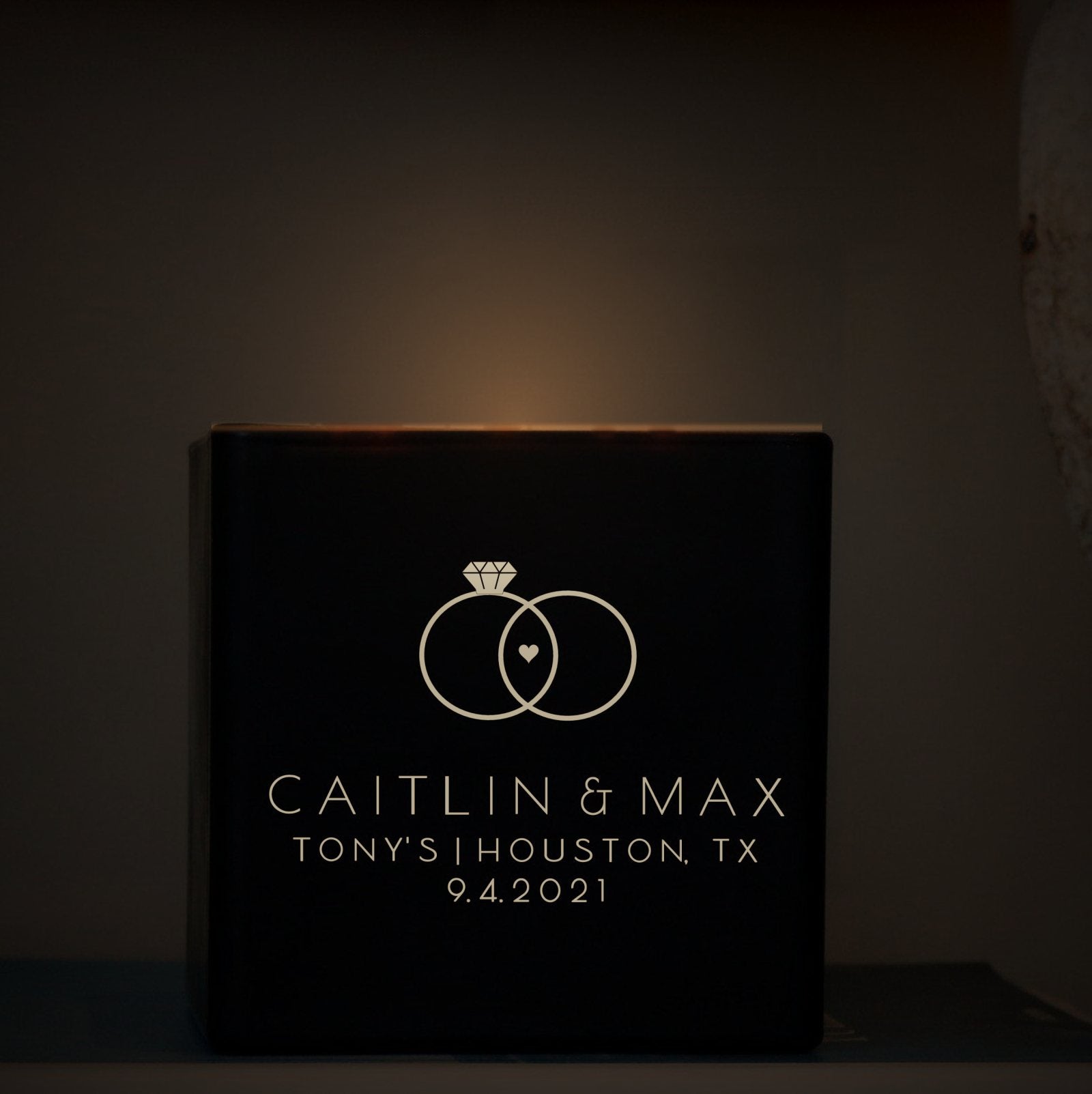 An engraved wedding candle glowing by candlelight