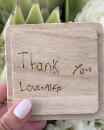 A wooden lid engraved Thank you, love Alfie in a child's handwriting