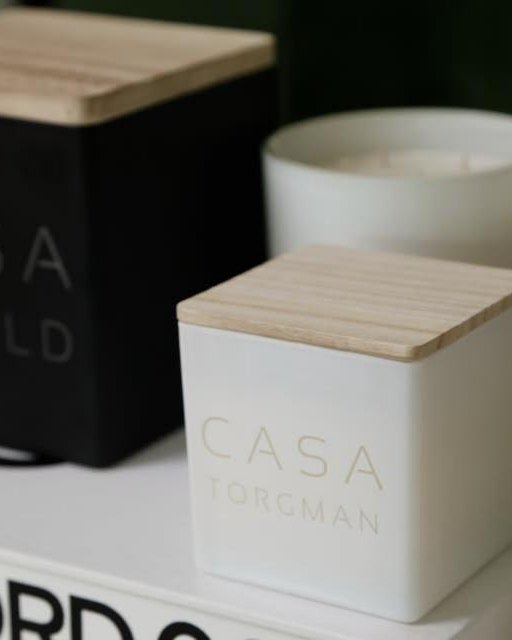 A white Casa Torgman candle beside a black Casa candle